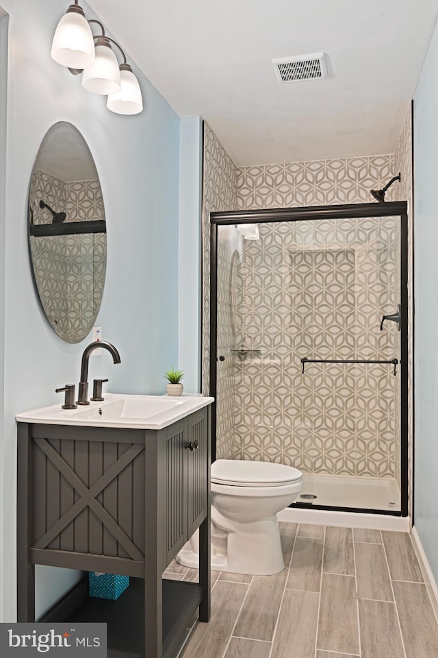 full bath featuring toilet, visible vents, and a stall shower