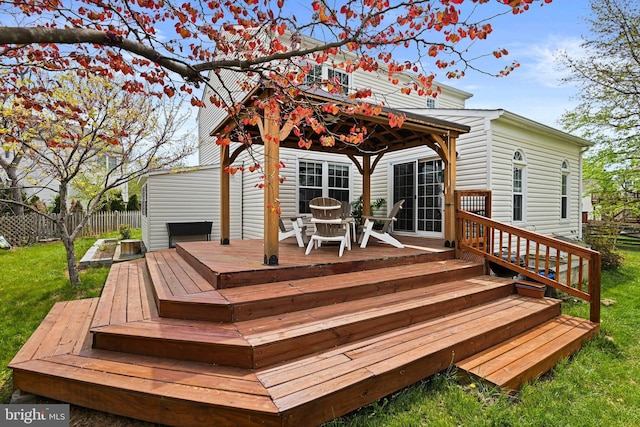 deck featuring a lawn, a gazebo, fence, and outdoor dining space