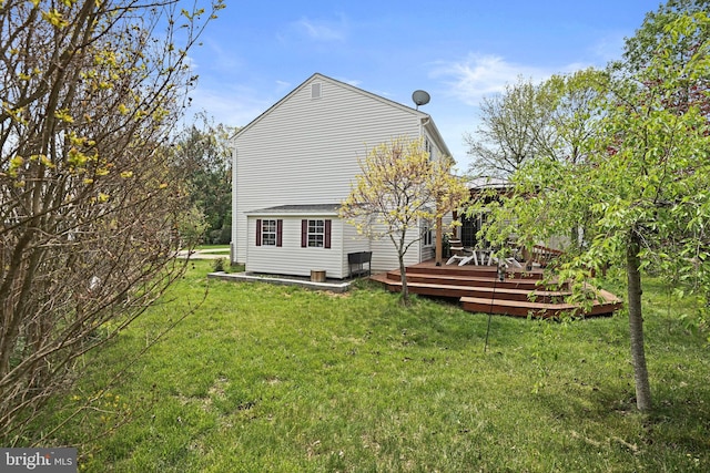 rear view of house featuring a yard and a wooden deck