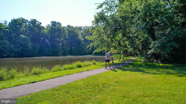 view of property's community featuring a lawn and a wooded view