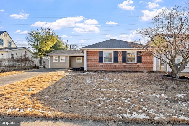 ranch-style home with roof with shingles and brick siding