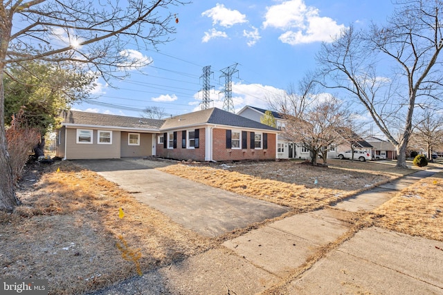 single story home featuring brick siding, driveway, and a shingled roof