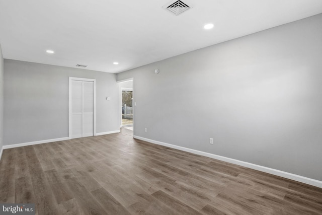 empty room with visible vents, baseboards, recessed lighting, and wood finished floors