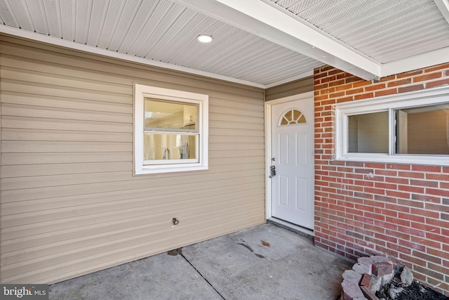 view of exterior entry with brick siding