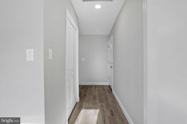 corridor with visible vents, baseboards, and wood finished floors