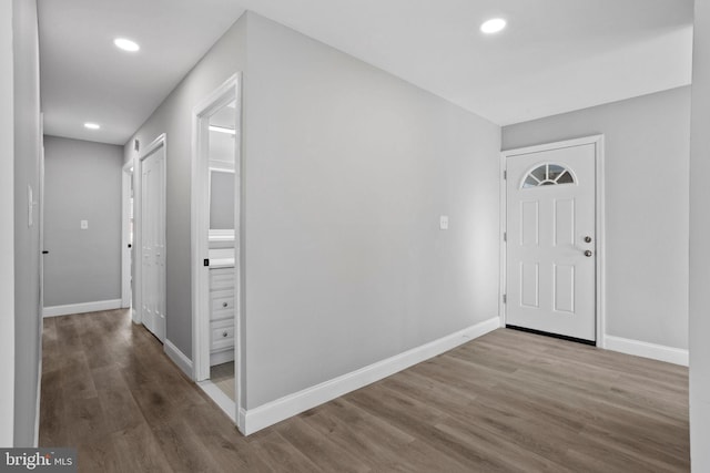 foyer entrance with wood finished floors, baseboards, and recessed lighting