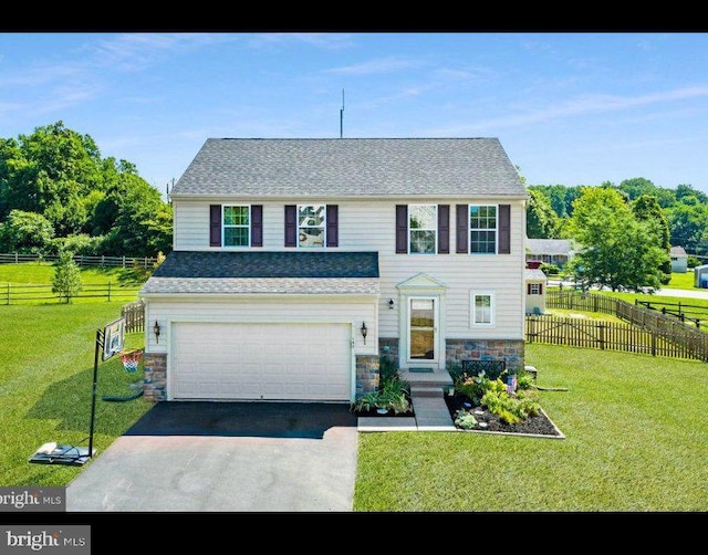 traditional home with an attached garage, stone siding, a front yard, and driveway