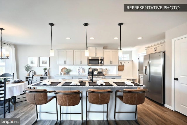 93 Long Bend Dr Lot 155, Carlisle, PA 17015 - kitchen featuring appliances with stainless steel finishes, a kitchen island with sink, a sink, and dark wood-style floors