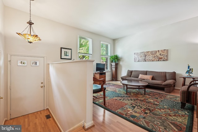 living room with light wood finished floors, baseboards, and visible vents