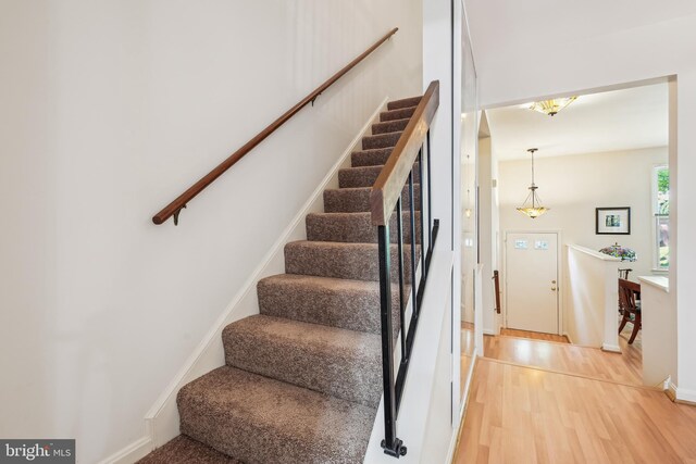 stairs featuring wood finished floors and baseboards