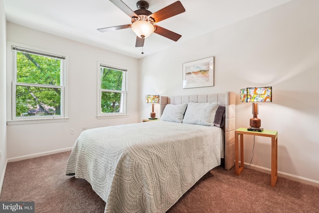 carpeted bedroom with multiple windows, baseboards, and a ceiling fan