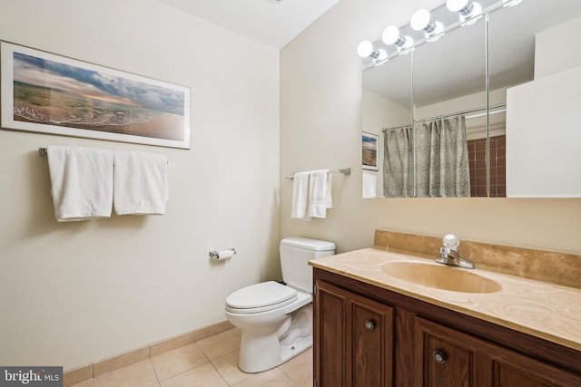 bathroom featuring toilet, vanity, curtained shower, tile patterned floors, and baseboards