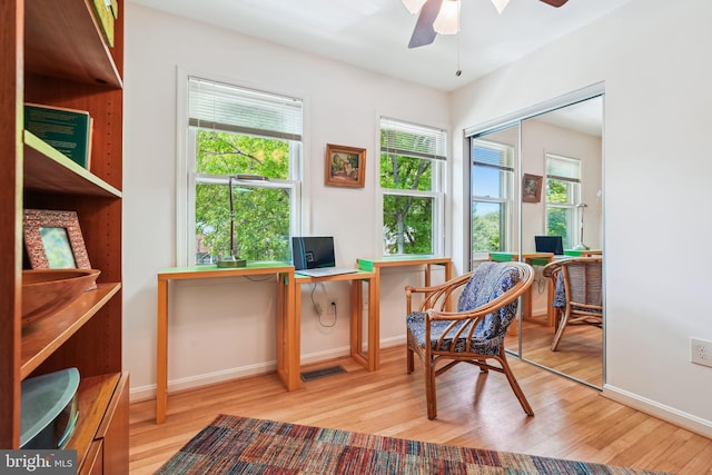 sitting room featuring light wood-style floors, visible vents, baseboards, and a ceiling fan