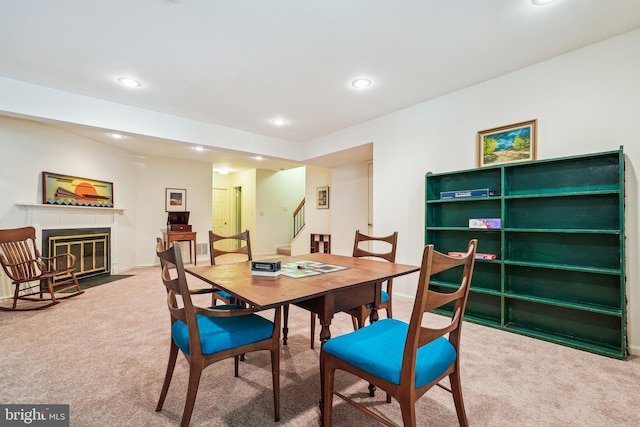 dining room featuring stairway, recessed lighting, carpet floors, and a fireplace with flush hearth