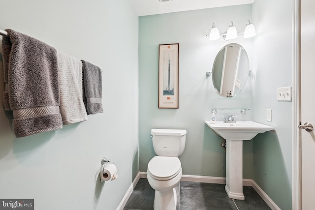 bathroom with toilet and baseboards