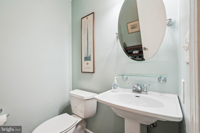 half bath featuring toilet and a sink