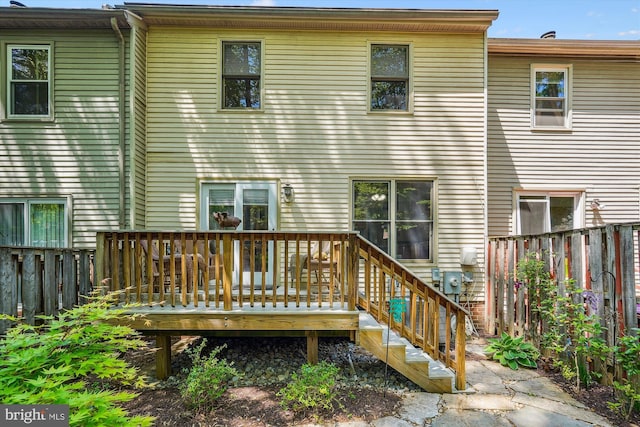 rear view of property featuring fence and a deck