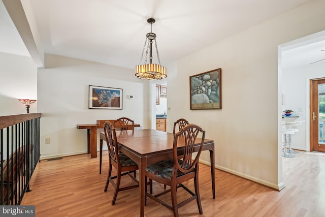 dining area featuring baseboards and light wood-style flooring