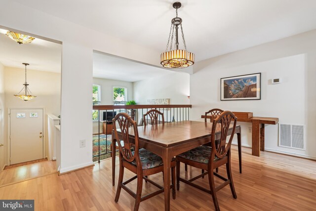 dining room featuring baseboards, light wood-style flooring, and visible vents