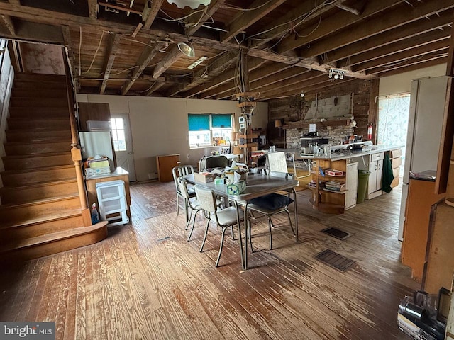 dining space with visible vents, stairway, and hardwood / wood-style flooring