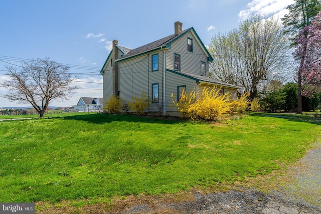 view of property exterior with a yard and a chimney