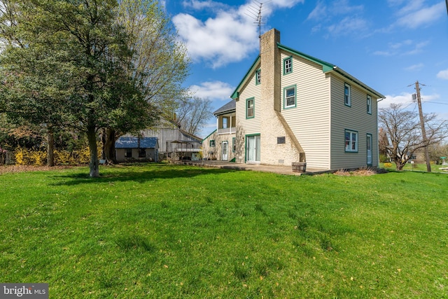 rear view of property with a yard and a chimney