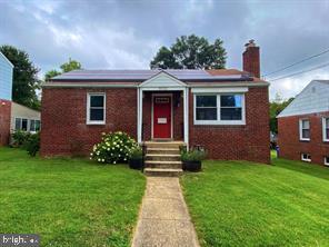 bungalow-style home featuring a front yard, brick siding, and a chimney