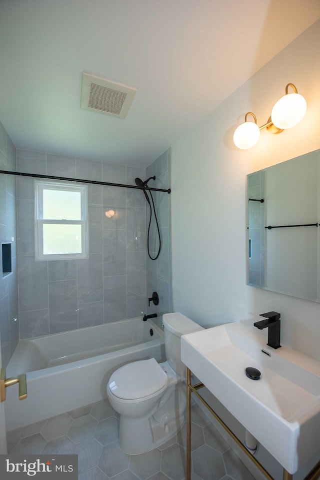 bathroom featuring vanity, tile patterned flooring, toilet, visible vents, and bathtub / shower combination