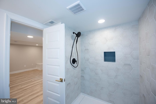 bathroom featuring recessed lighting, visible vents, a tile shower, and wood finished floors
