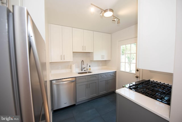 kitchen featuring a sink, light countertops, white cabinetry, stainless steel appliances, and backsplash
