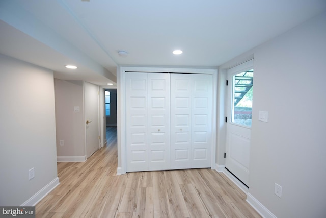unfurnished bedroom featuring a closet, light wood finished floors, baseboards, and recessed lighting