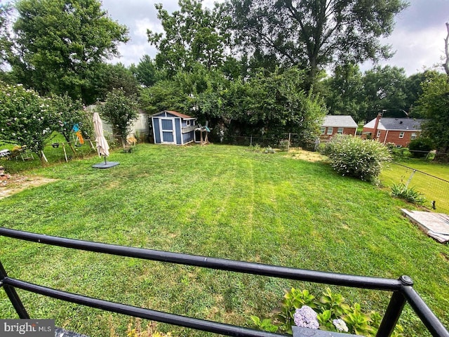 view of yard featuring a storage shed, a fenced backyard, and an outdoor structure