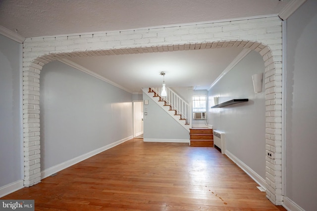 entryway with radiator, light wood-style floors, stairs, ornamental molding, and baseboards