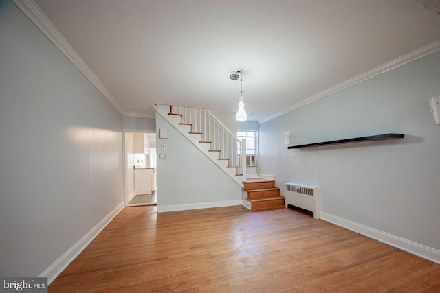 foyer with radiator heating unit, stairs, ornamental molding, light wood finished floors, and baseboards