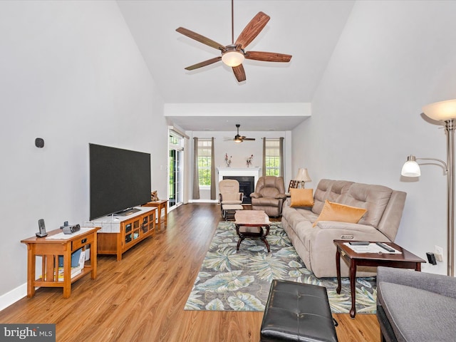 6538 Autumn Olive Dr, Frederick, MD 21703 - living room featuring baseboards, a fireplace, ceiling fan, high vaulted ceiling, and light wood finished floors