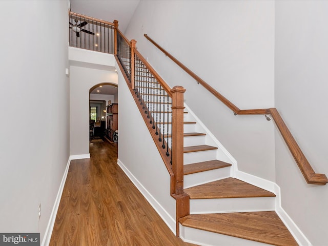 6538 Autumn Olive Dr, Frederick, MD 21703 - staircase with arched walkways, a high ceiling, baseboards, and wood finished floors