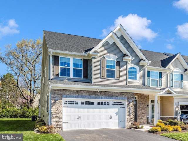6538 Autumn Olive Dr, Frederick, MD 21703 - view of front facade featuring central AC, a shingled roof, stone siding, a garage, and driveway