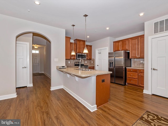 6538 Autumn Olive Dr, Frederick, MD 21703 - kitchen with dark wood-style floors, brown cabinets, stainless steel appliances, arched walkways, and a sink