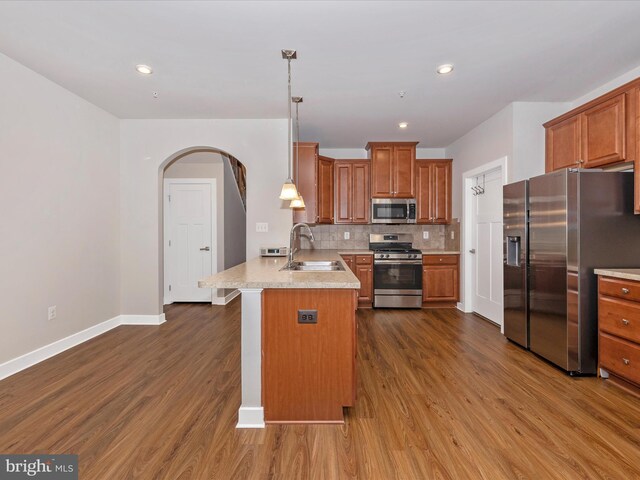 6538 Autumn Olive Dr, Frederick, MD 21703 - kitchen with a peninsula, appliances with stainless steel finishes, a sink, brown cabinets, and decorative backsplash