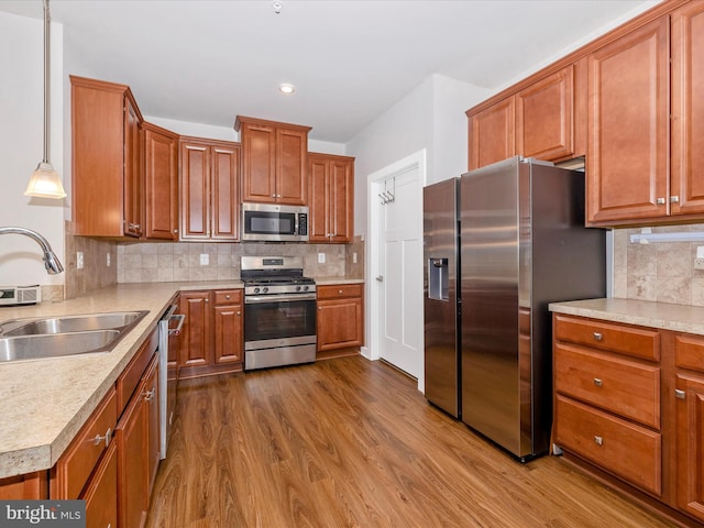 6538 Autumn Olive Dr, Frederick, MD 21703 - kitchen with dark wood-style flooring, light countertops, a sink, stainless steel appliances, and brown cabinets
