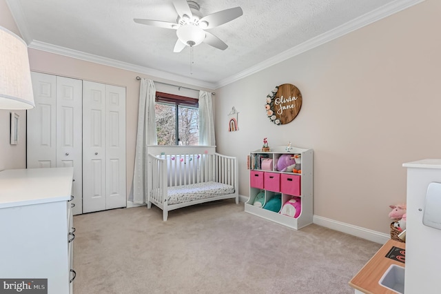 bedroom featuring a closet, baseboards, ornamental molding, ceiling fan, and light carpet