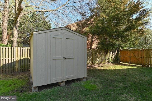view of shed featuring a fenced backyard and a gate