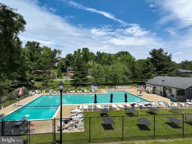 pool featuring a yard, a patio area, and fence