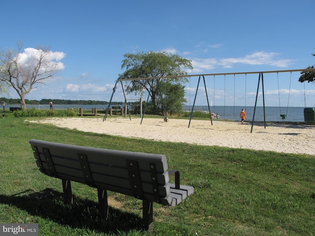 view of property's community featuring a lawn, a water view, and playground community