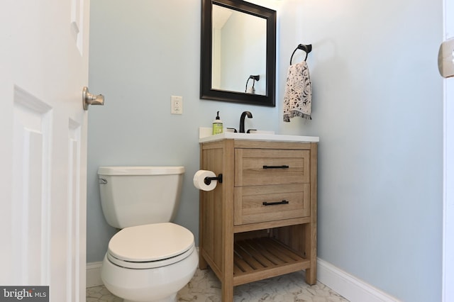 bathroom with vanity, baseboards, and toilet