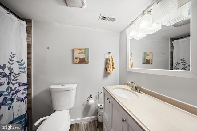1107 Elfin Ave, Capitol Heights, MD 20743 - full bath with toilet, baseboards, visible vents, wood finished floors, and vanity