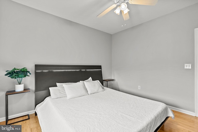 bedroom with baseboards, a ceiling fan, and wood finished floors