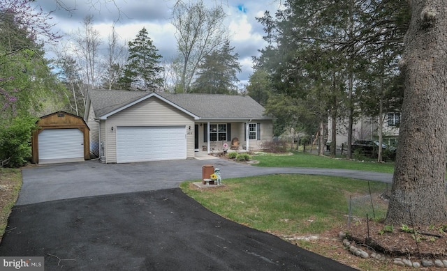 ranch-style home with roof with shingles, covered porch, a garage, a front yard, and aphalt driveway