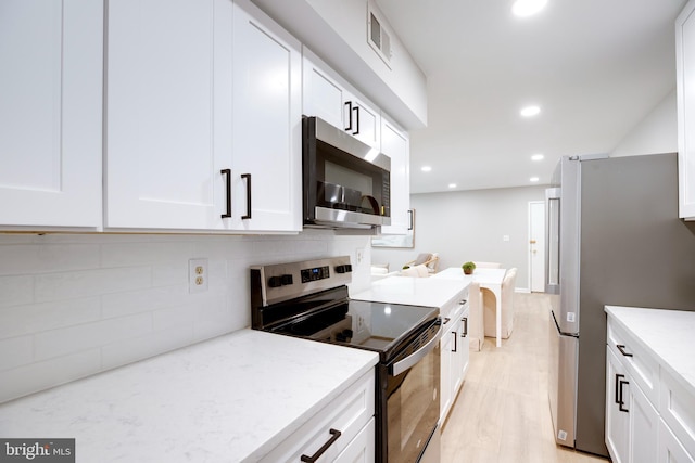 5901 Kingsford Rd Unit 440, Springfield, VA 22152 - kitchen featuring light stone counters, white cabinets, tasteful backsplash, and stainless steel appliances