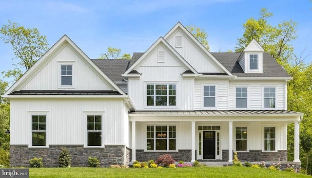modern inspired farmhouse with board and batten siding, a standing seam roof, covered porch, and metal roof